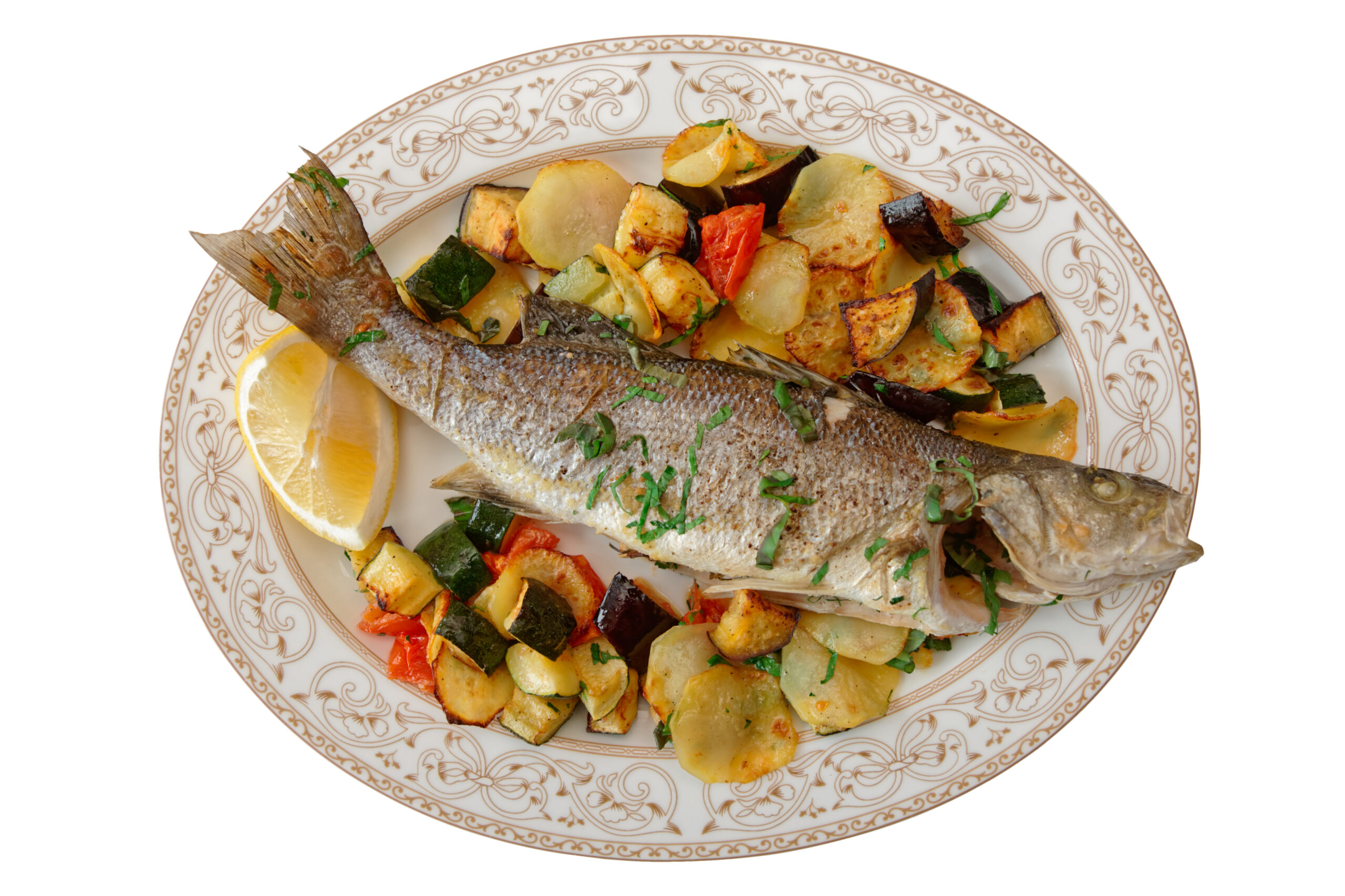 Fried sea bass with baked vegetables shot from above, Italian dish, isolated on white background