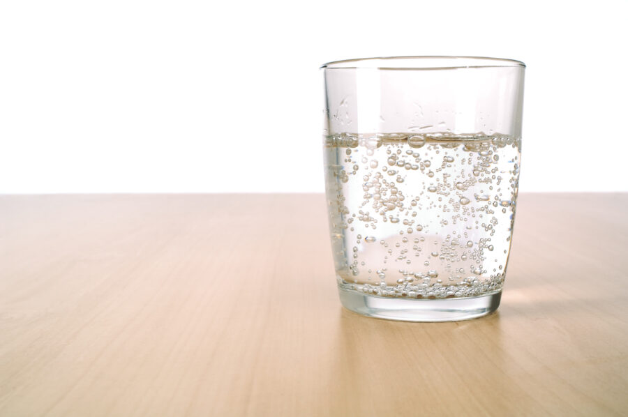 Glass of sparkling water on table
