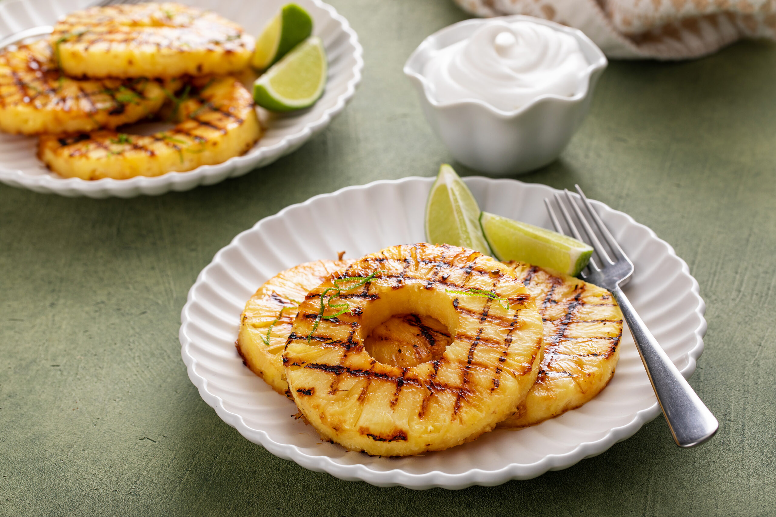 Grilled pineapple with lime honey glaze, lime zest and whipped cream