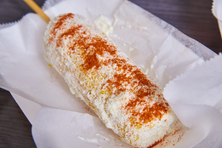 elote corn street food Mexican food dish cotija cheese spicy chili powder on white dish