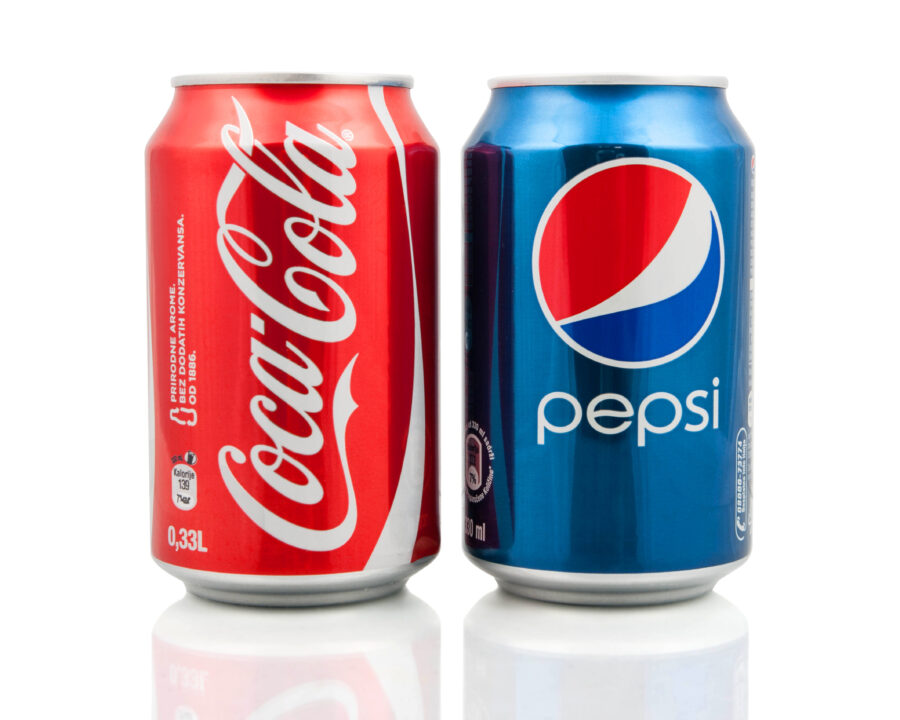 Coca-Cola and Pepsi cans on white background. 