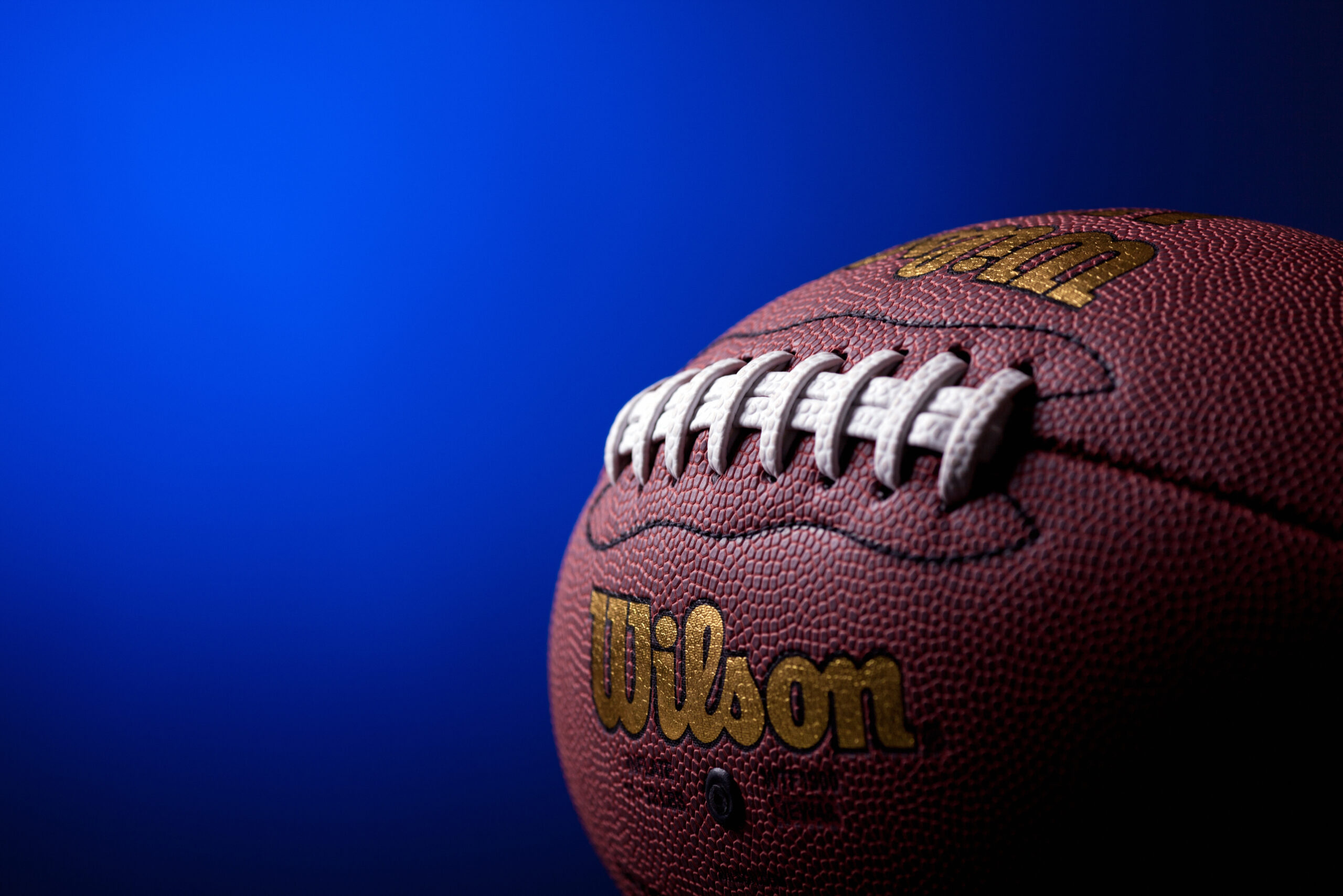 "Kragujevac, Serbia - November 17, 2012: Wilson Composite leather replica of the official NFL American football ball. Photo taken in studio, with blue gradient in the background"