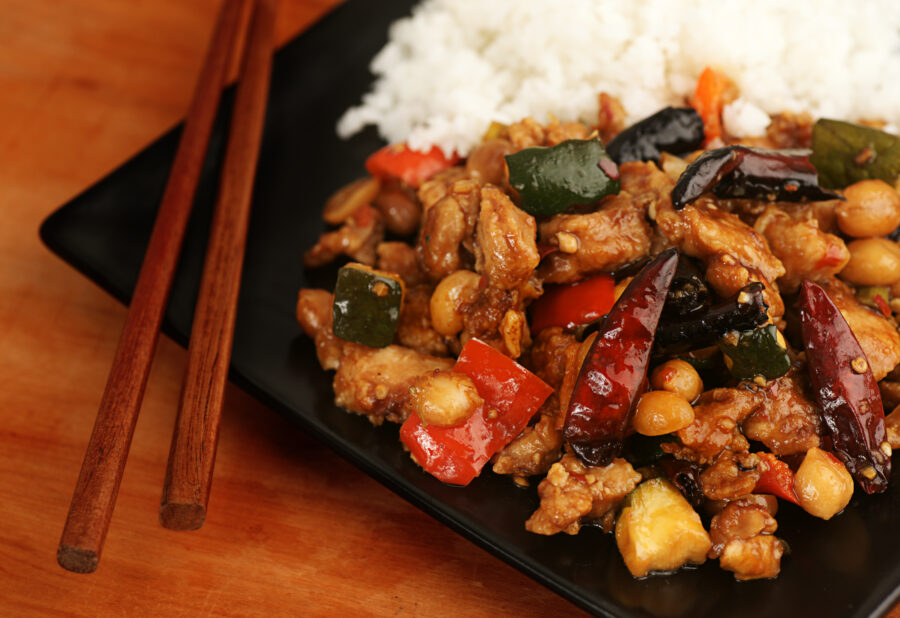 Kung Pao chicken made with sweet red peppers, zucchini squash, peanuts, dried chili peppers, and served with steamed rice.