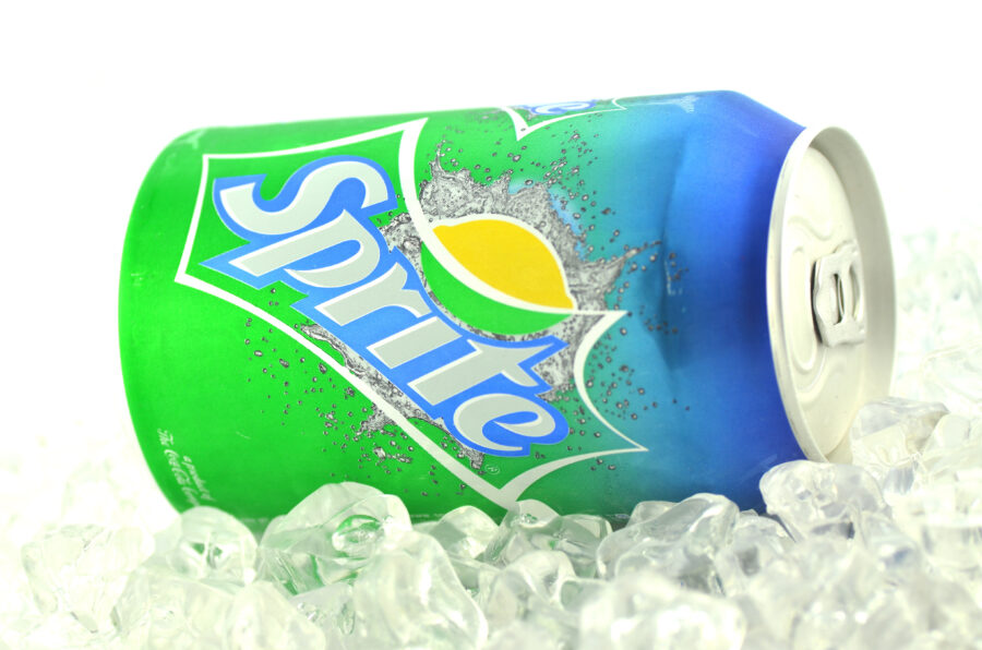 Sprite drink in can on ice isolated on white background. 