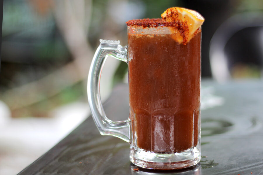 Micheladas served on an outdoor table, it is a Mexican alcoholic drink that is prepared by mixing beer, lemon juice, chili, salt and shrimp