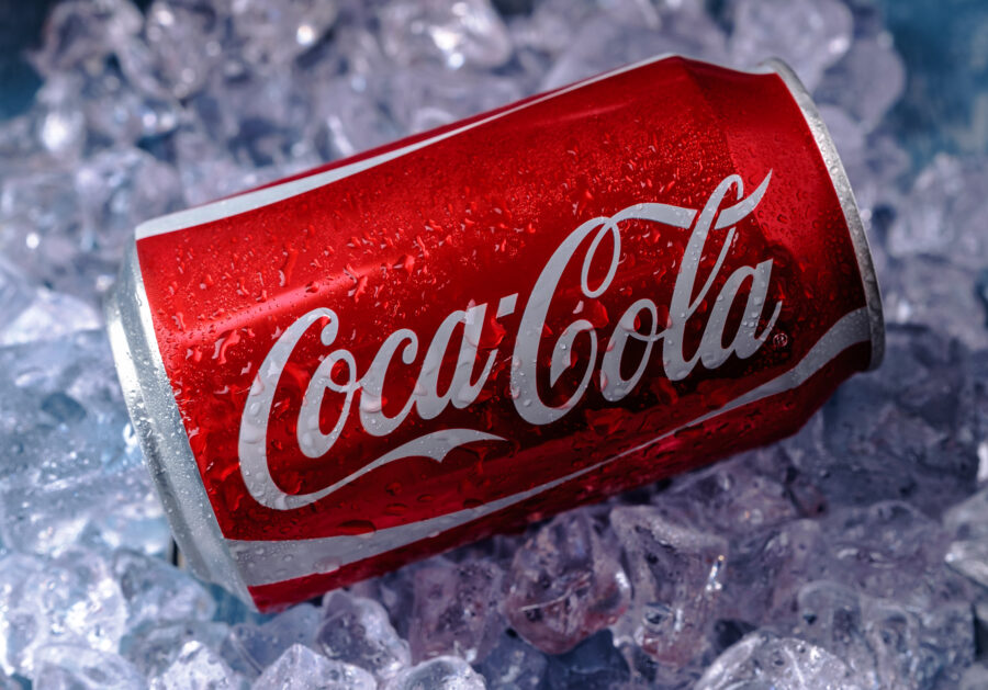 Can of Coca-Cola on a bed of ice over a blue background