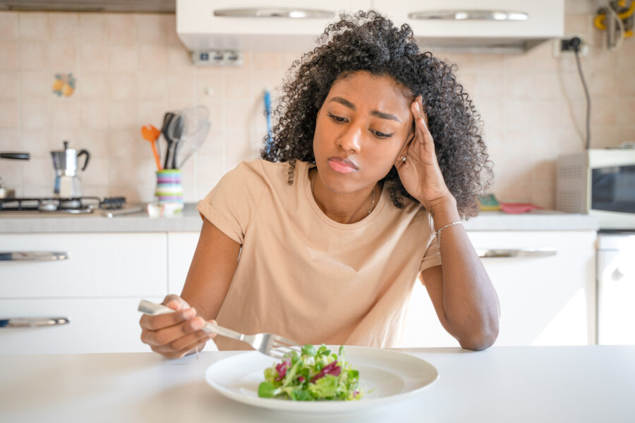 One black woman feeling hungry eating poor calories food for diet