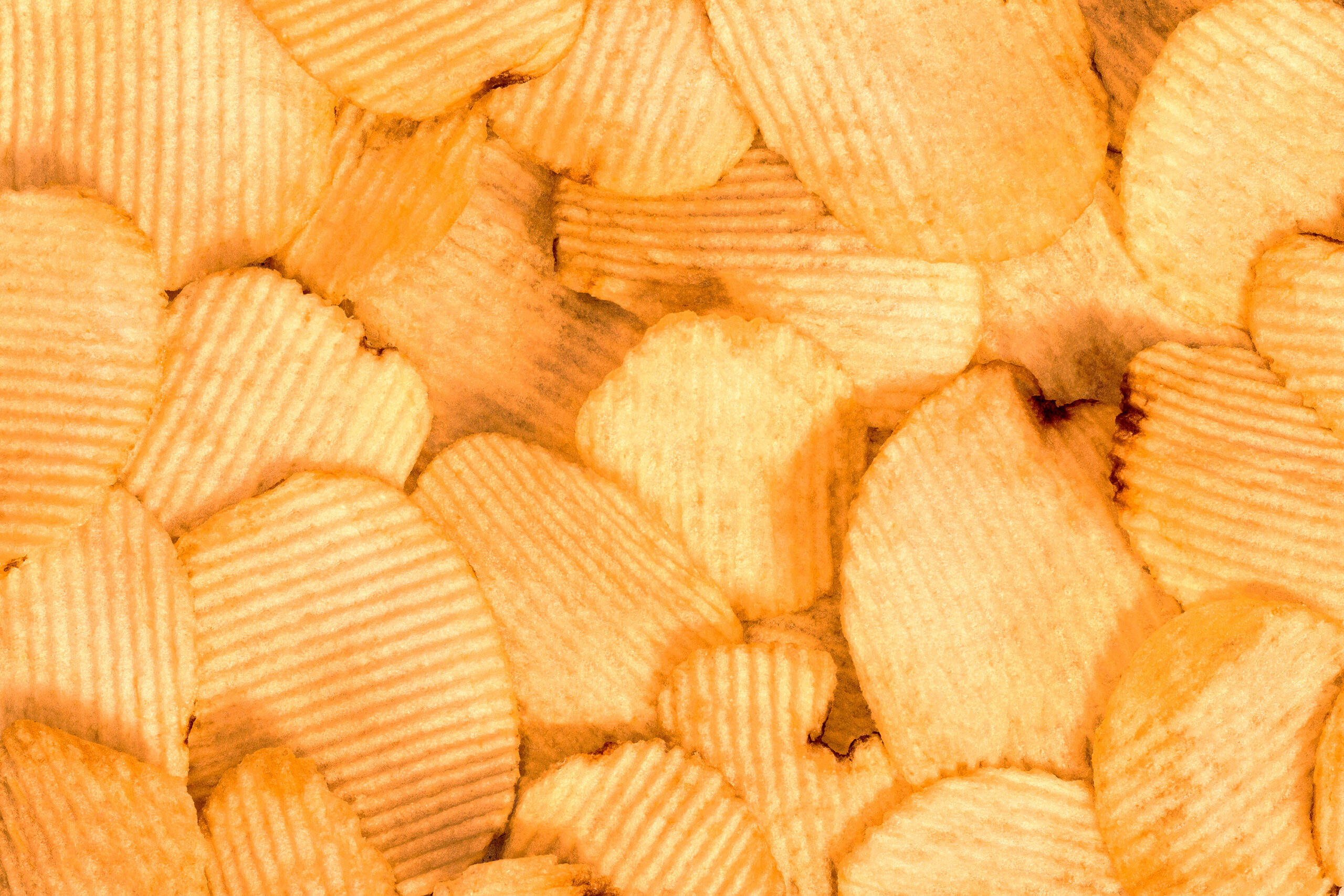 Potato chips background. Fast Food snack texture.