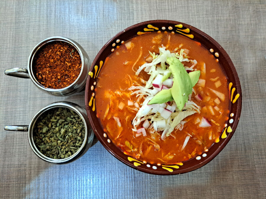 Pozole is a traditional soup or stew from Mexican cuisine, with hominy, meat, and can be seasoned and garnished with shredded lettuce, chile peppers, onion