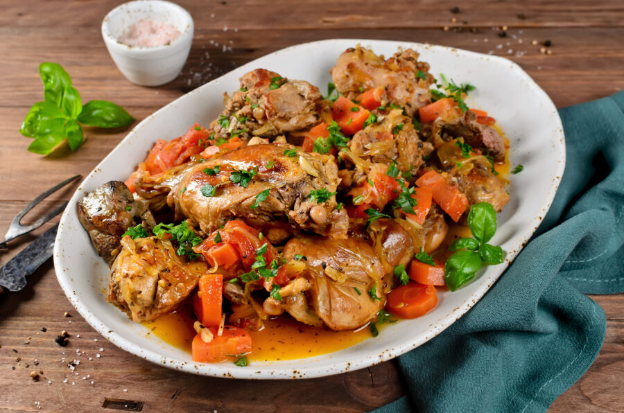 Rabbit stew with onions, carrots and tomatoes. Meat with vegetables stewed in white wine sauce