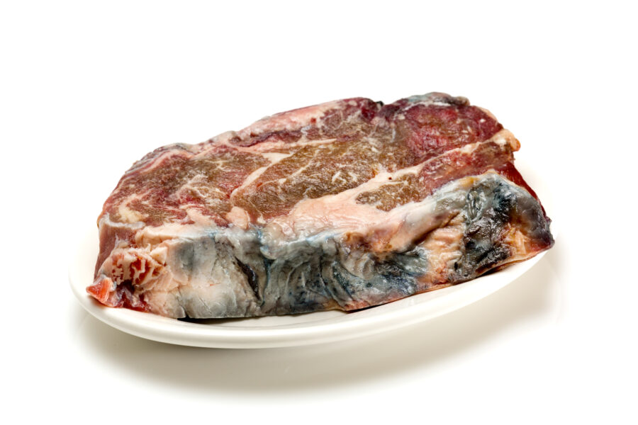 Raw spoiled steak on white.