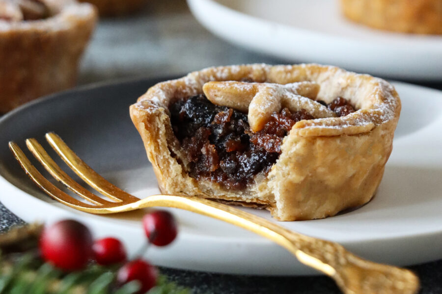 Stock photo showing close-up view of homemade, individual mince pie made with homemade short crust pastry topped with pastry star detail, hiding the sweet mincemeat 