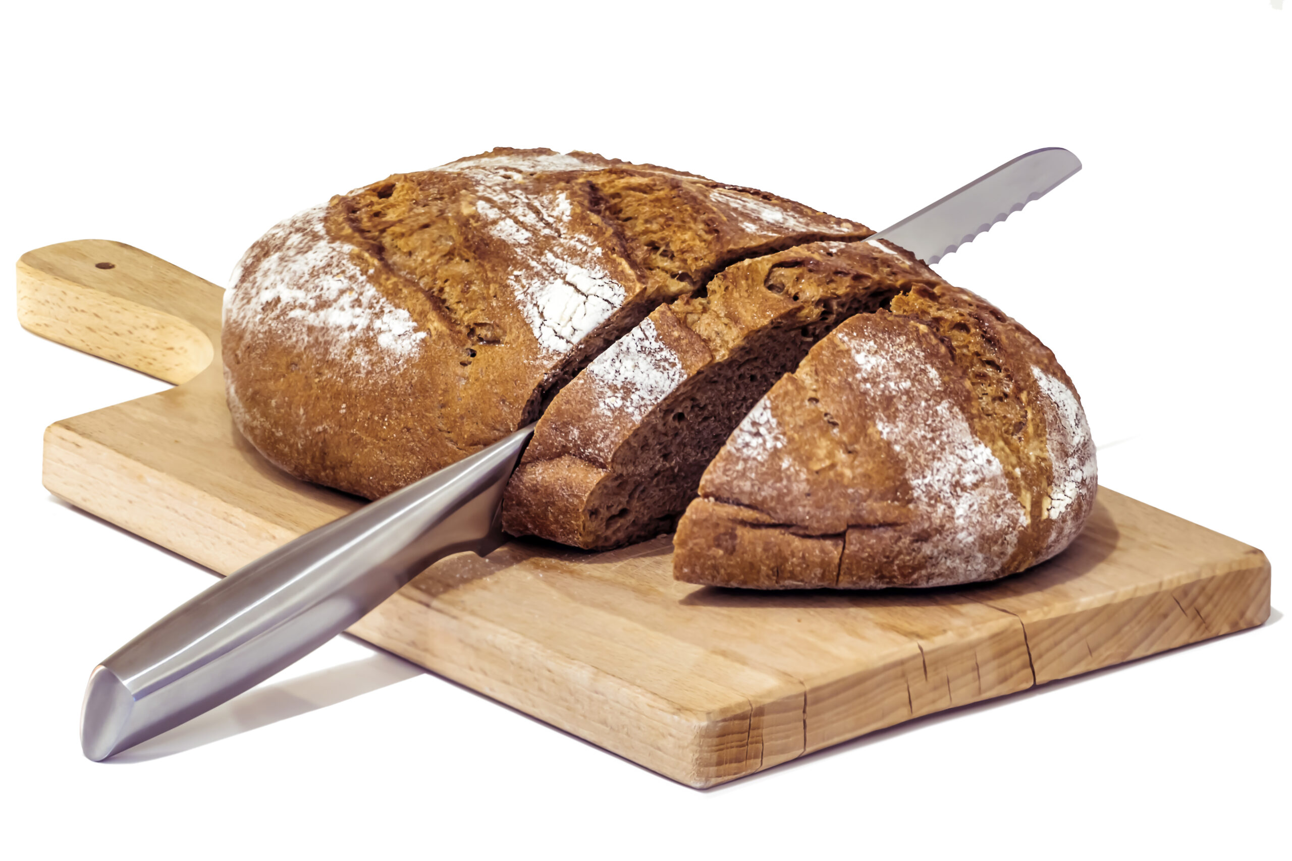 Studio shot of Rustic wholegrain brown bread loaf on wooden cutting board, sliced with stainless steel bread knife, set on neutral white background.