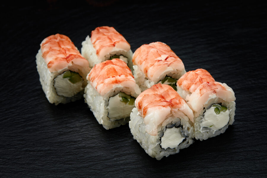 Sushi rolls Philadelphia with snow crab, cream cheese, cucumber, sesame seeds isolateed on black background.