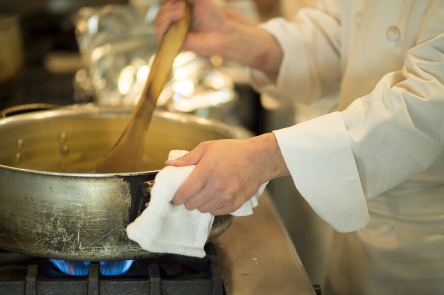 The chef stirring the contents of the pot