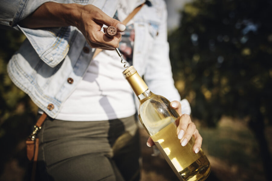 Wine bottle is opened with corkscrew.