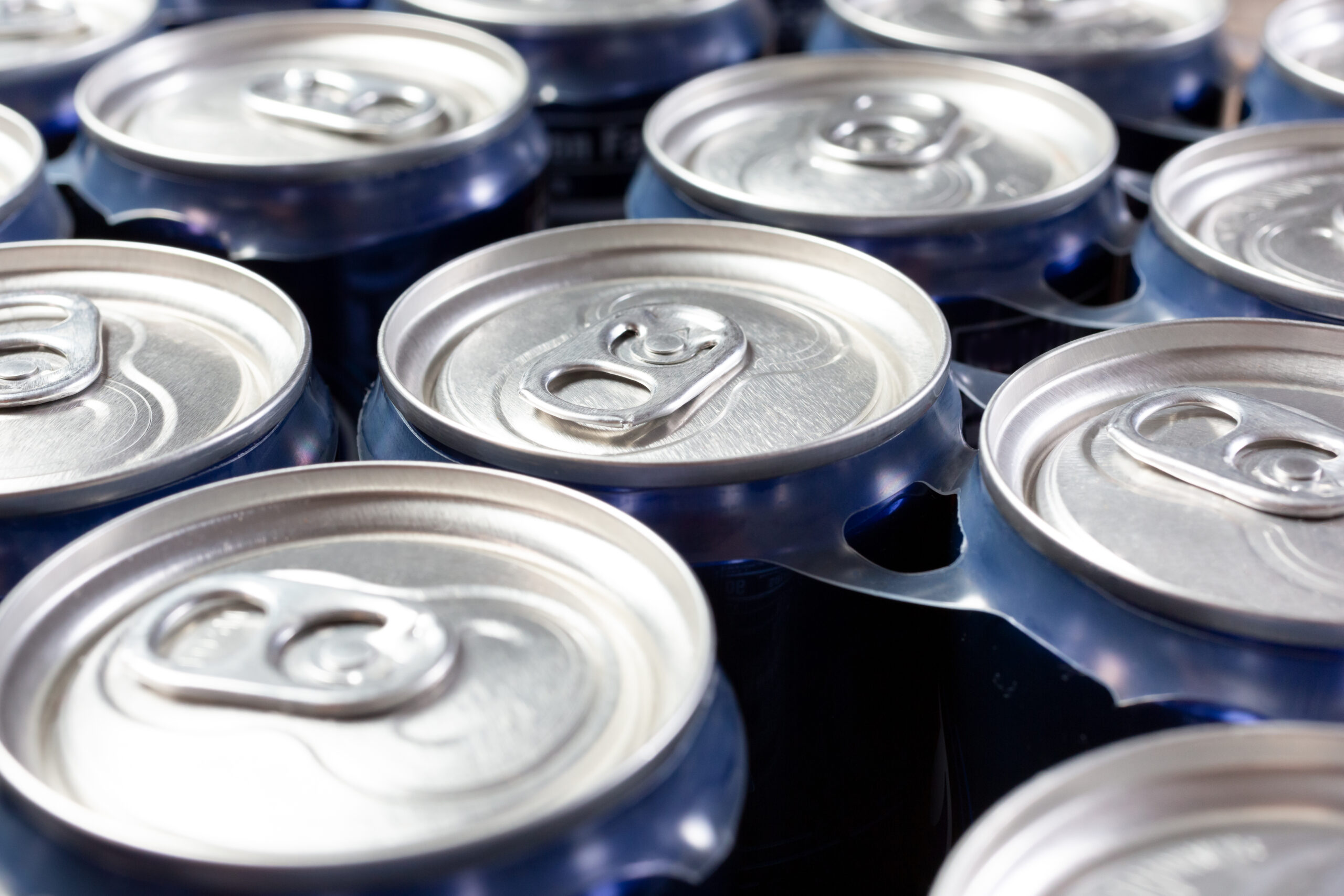 A closeup view of several top portions of soda cans, as a background.