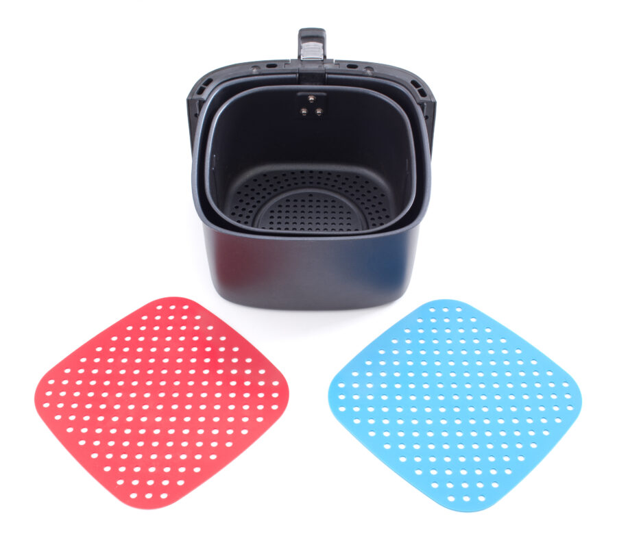 Air fryer basket and silicone liners on white