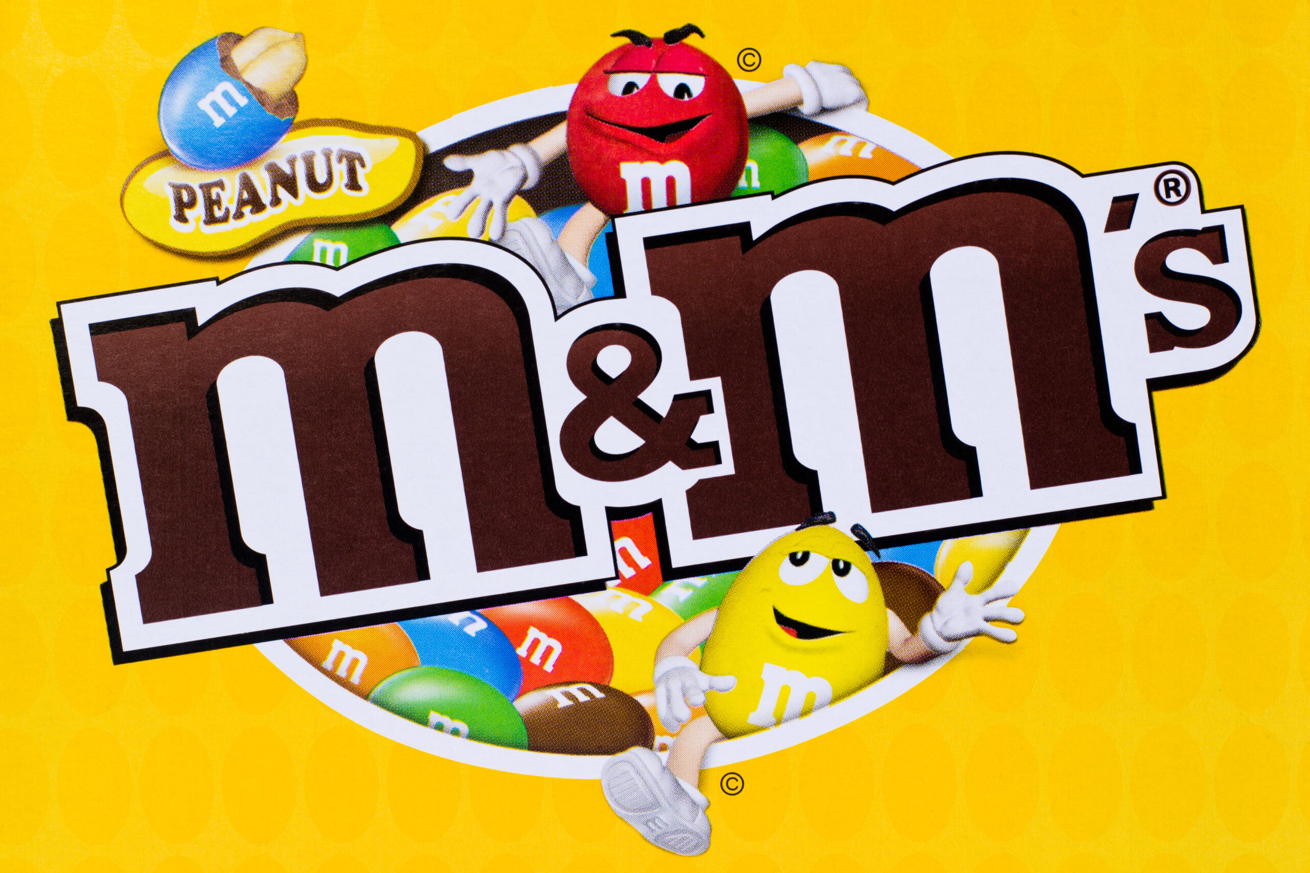 "Arad, Romania - March 24, 2012: Peanut M&M's logo printed on cardboard. M&M's are colorful button-shaped candies produced by Mars, Incorporated. Studio shot."