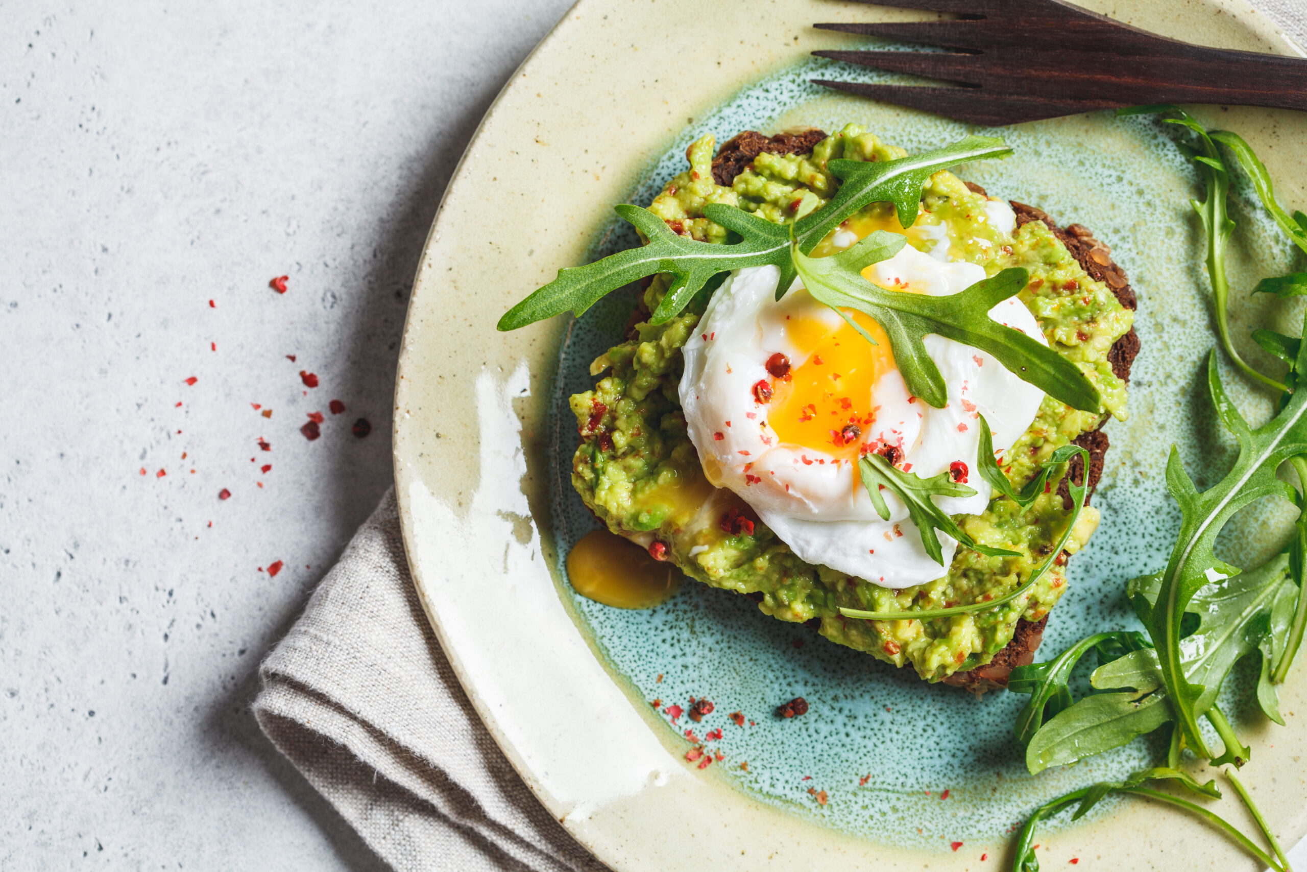 Avocado and poached egg toast on rye bread. Healthy breakfast concept.