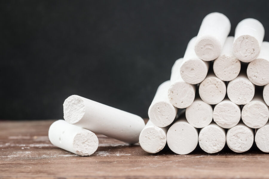 Close up of white chalk on wooden desk