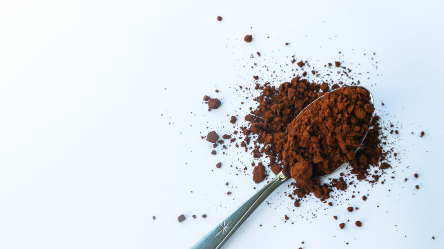 Coffee grounds in a spoon isolated on a white background.