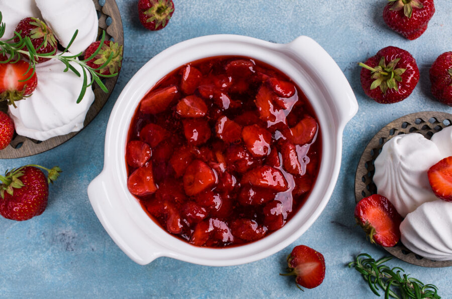 Dessert with slices of strawberries and marshmallows in a ceramic dish on the table. Selective focus.