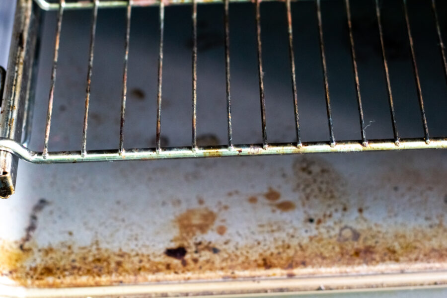 Dirty kitchen oven after cooking. The oven is greasy and stained.