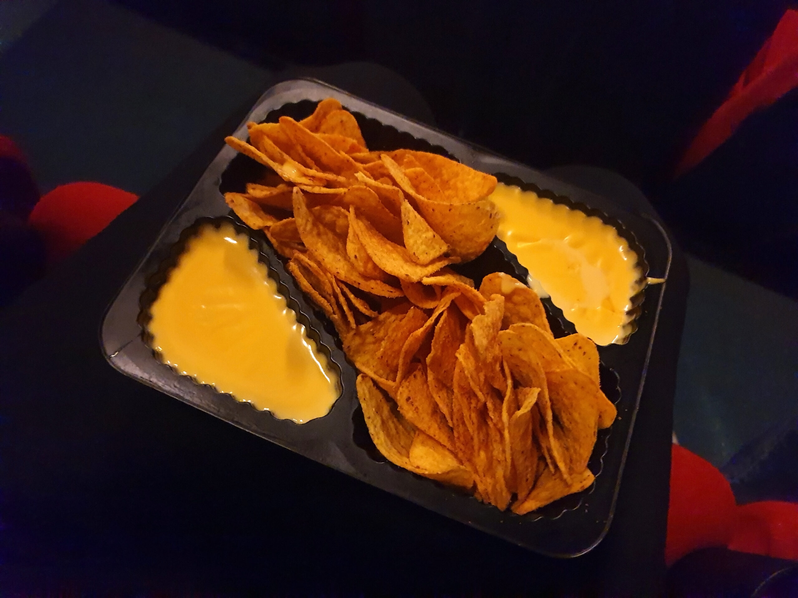 Empty cinema hall seat with nachos and cola