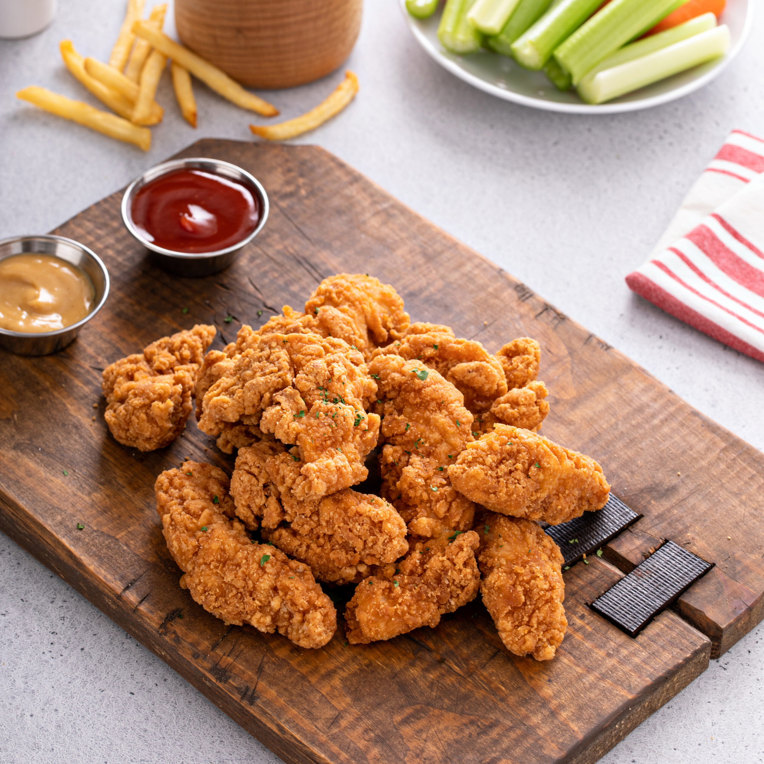 Fried chicken tenders or strips served with ketchup and fries