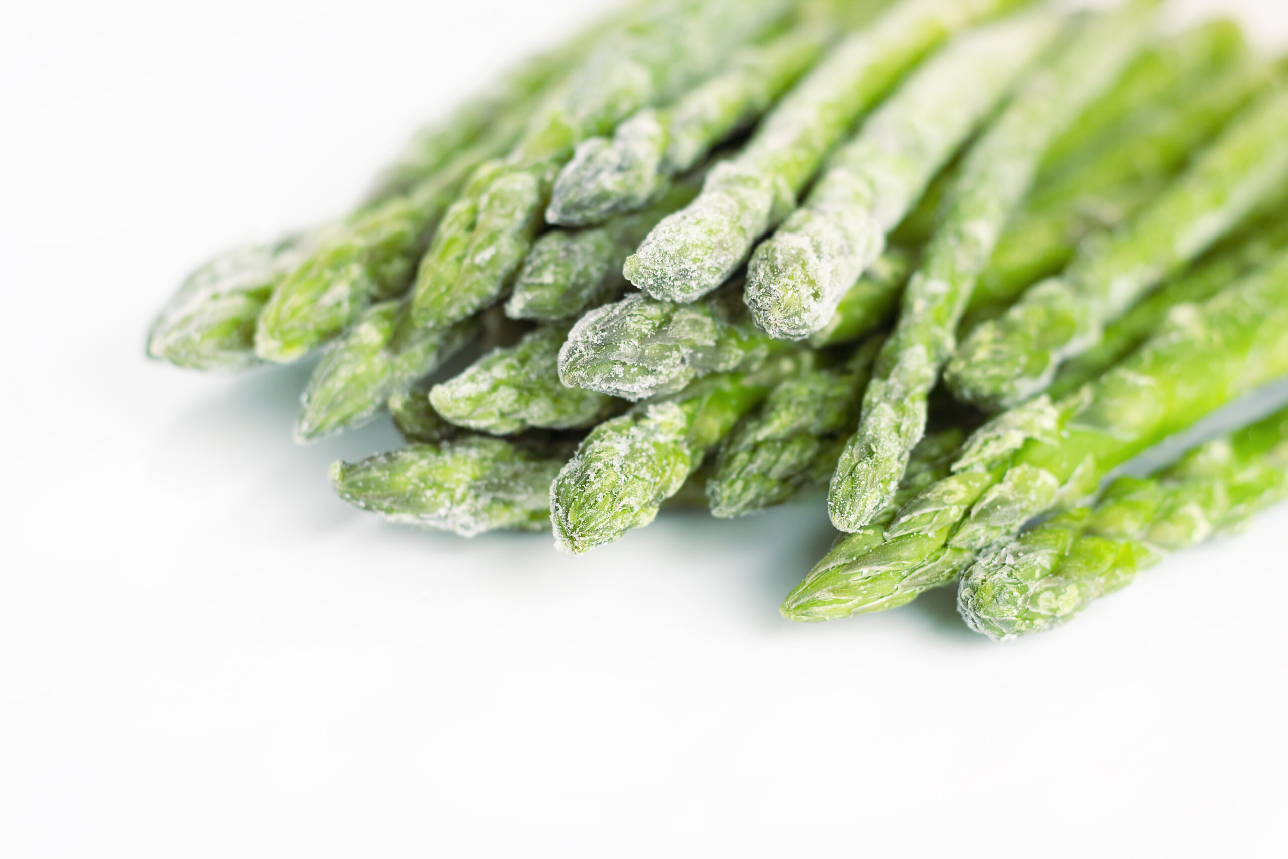 Frozen asparagus on a white background. Vegetable.