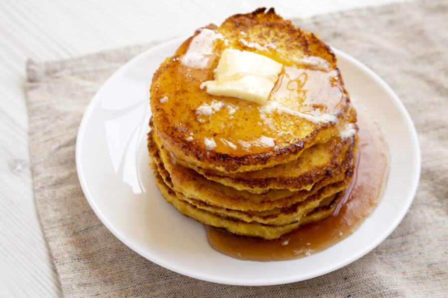 Homemade corn meal Johnny cakes  on a white plate, side view. Close-up.