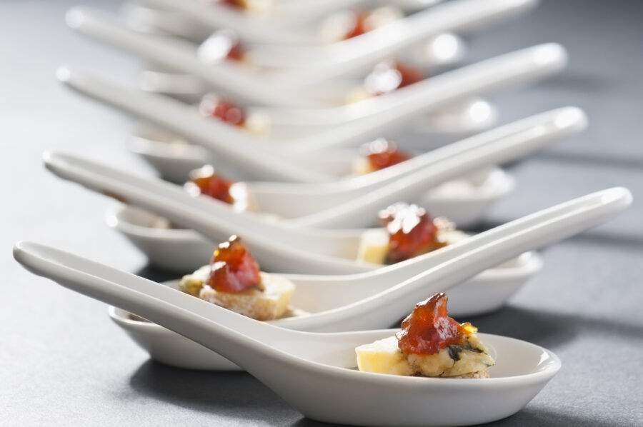 Miniature portions of cheese and biscuits served as canapés on chinese spoons