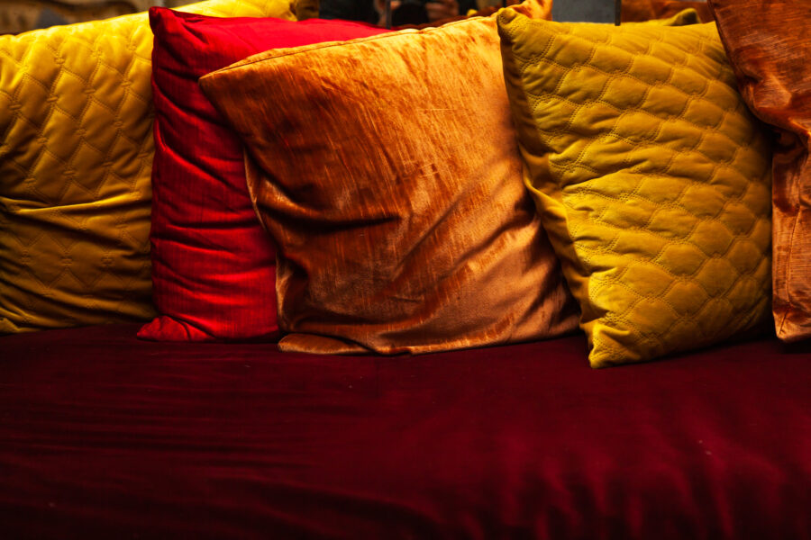 Modern living room interior with grey velvet sofa and colorful pillows at home