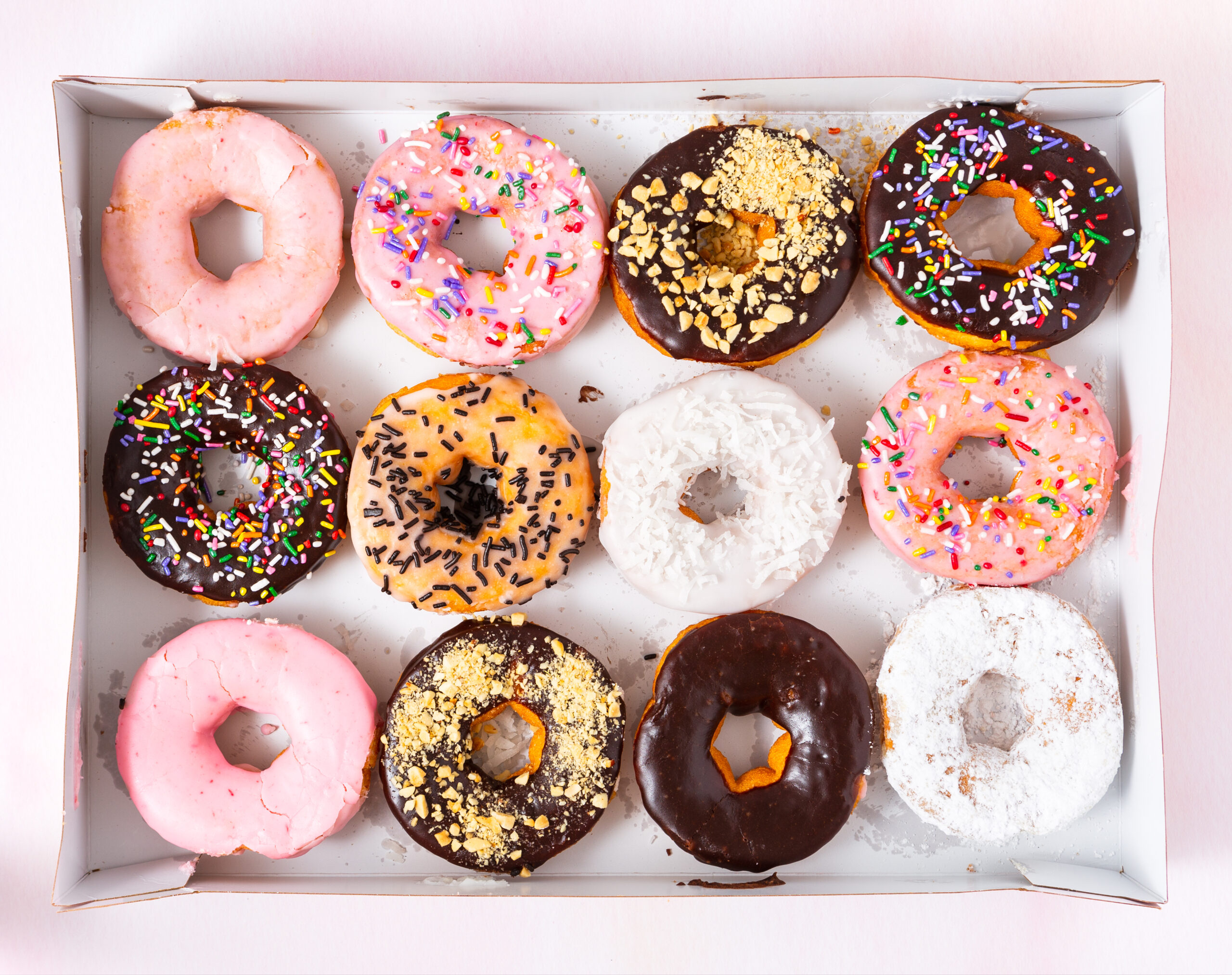 Overhead view of a dozen freshly baked doughnuts