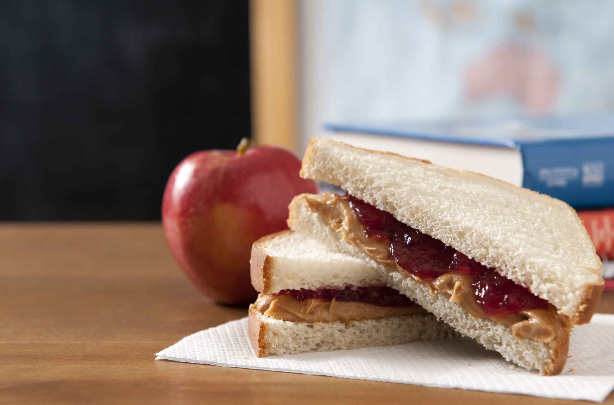 Peanut butter and jelly sandwich in  a classroom with a apple.  Please see my portfolio for other education and food related images.