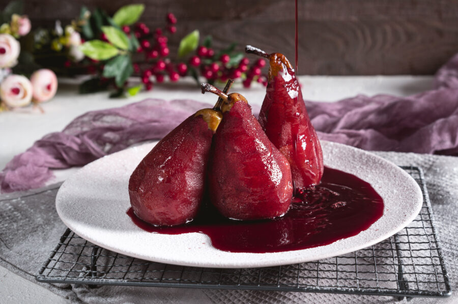 Pears in red wine on rustic background