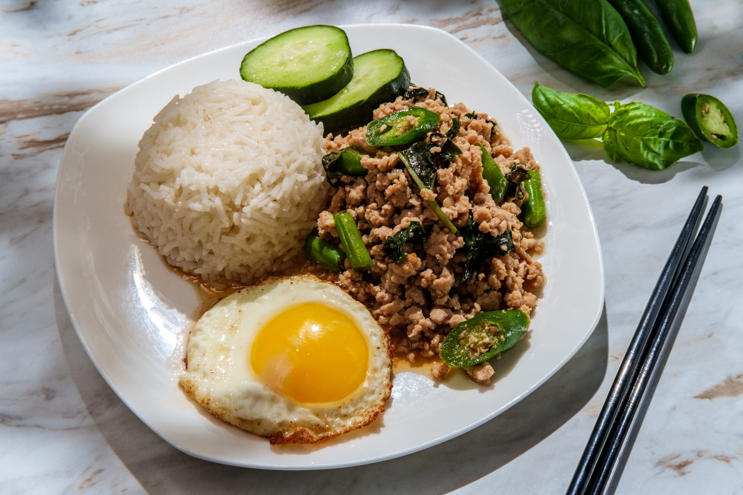 Phat Krapow Mu Sap also known as stir-fried Thai basil pork with oyster sauce served with white rice and a fried egg sunnyside up