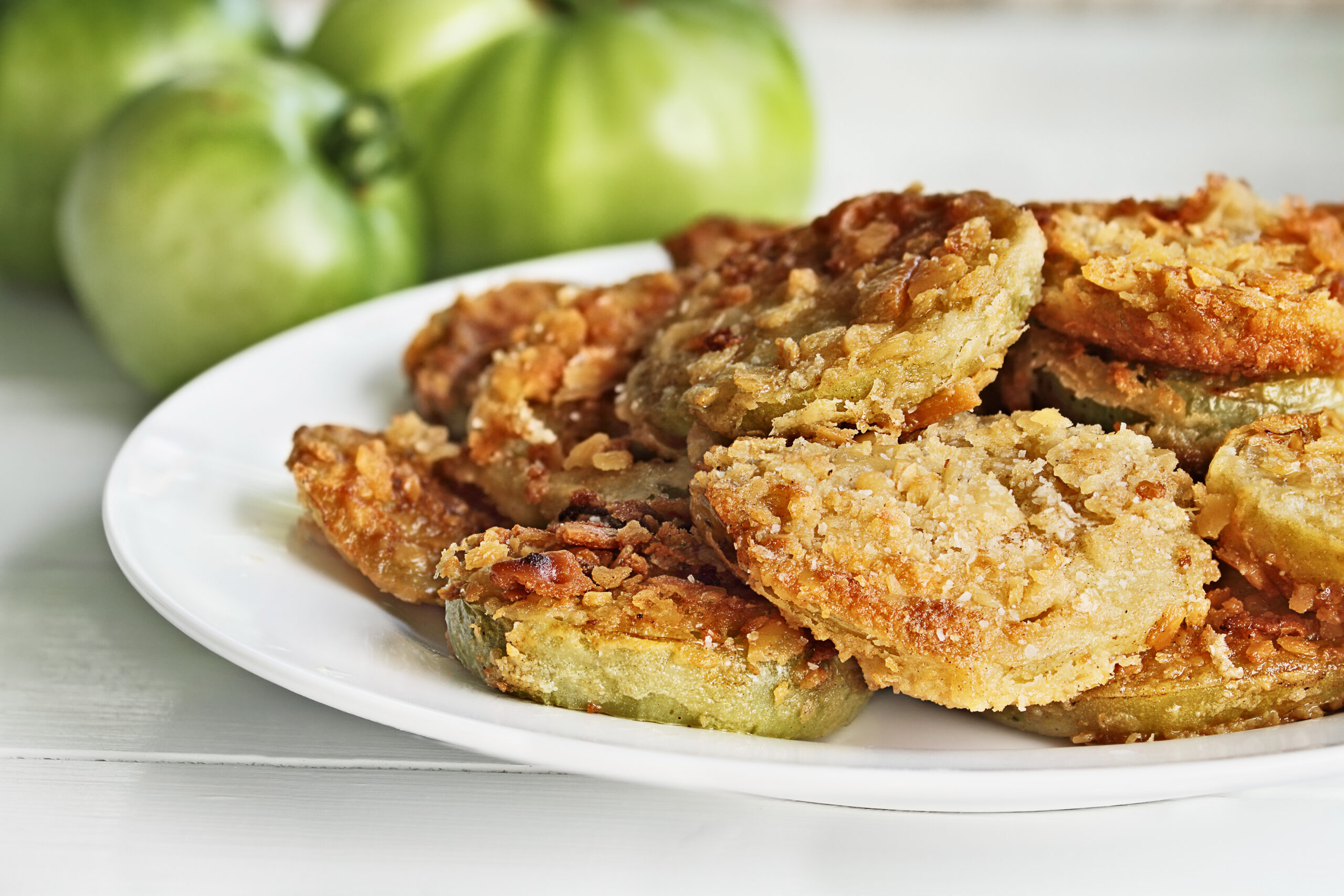 Plate of fresh fried green tomatoes. Extreme shallow depth of field with selective focus.