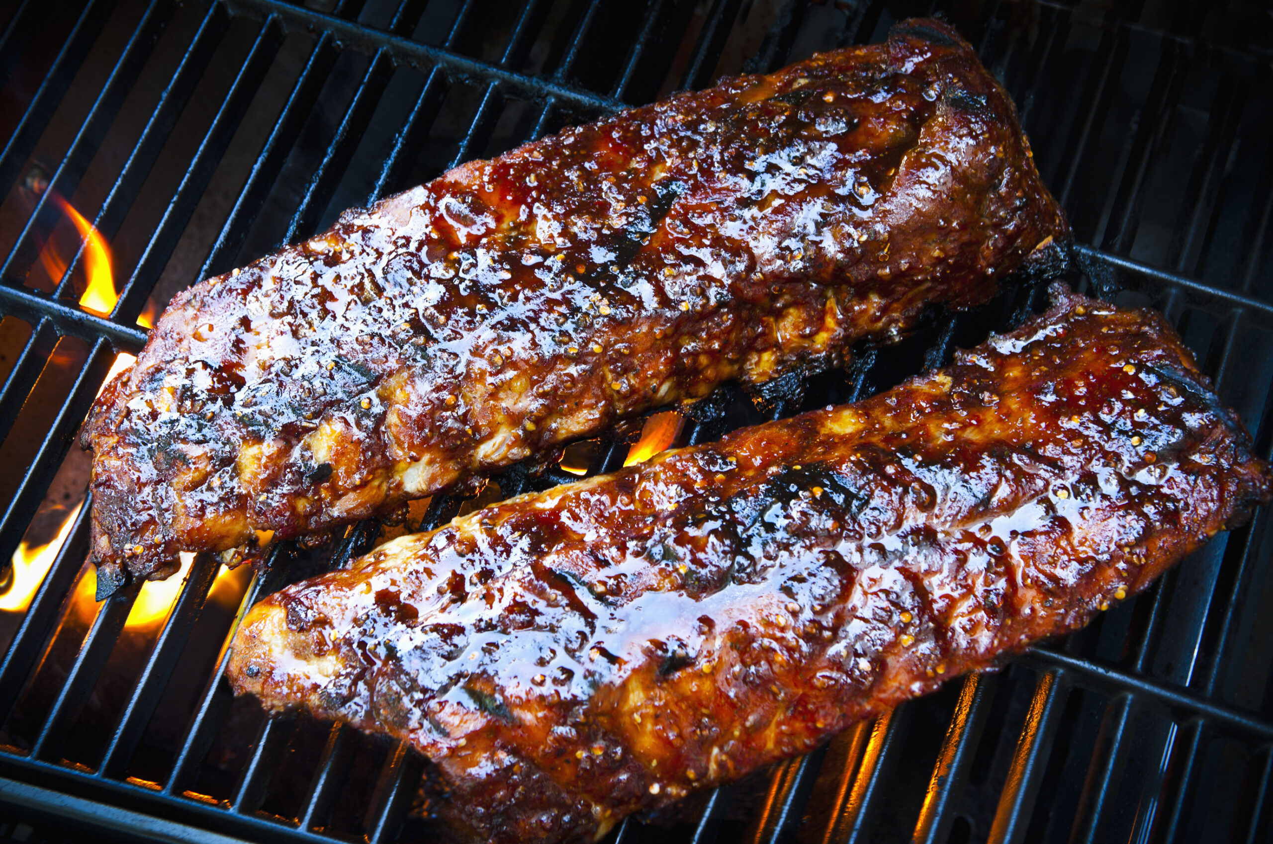 Rack of baby back pork ribs on bbq grill.