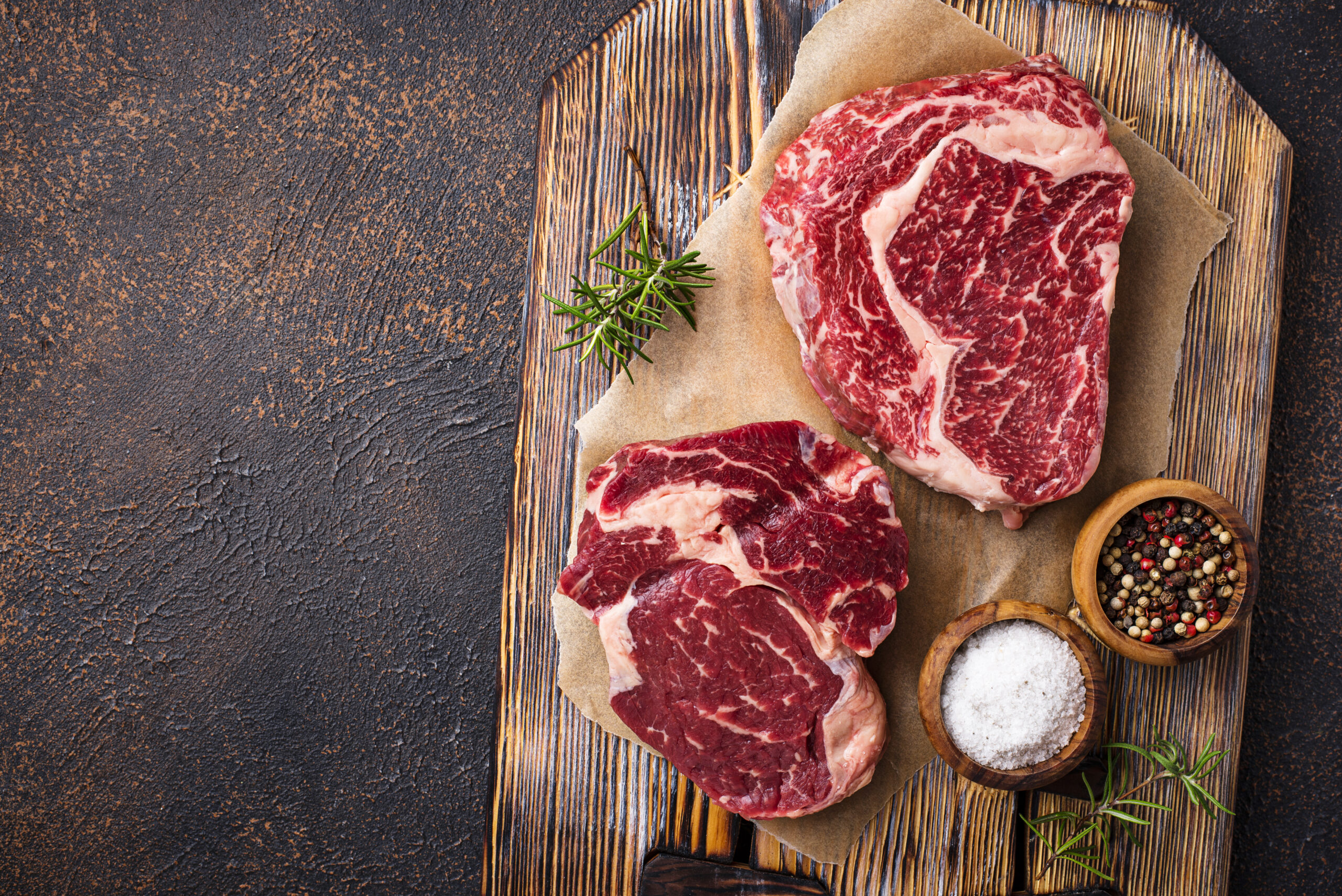 Raw marbled ribeye steak. Fresh meat and spices. Top view