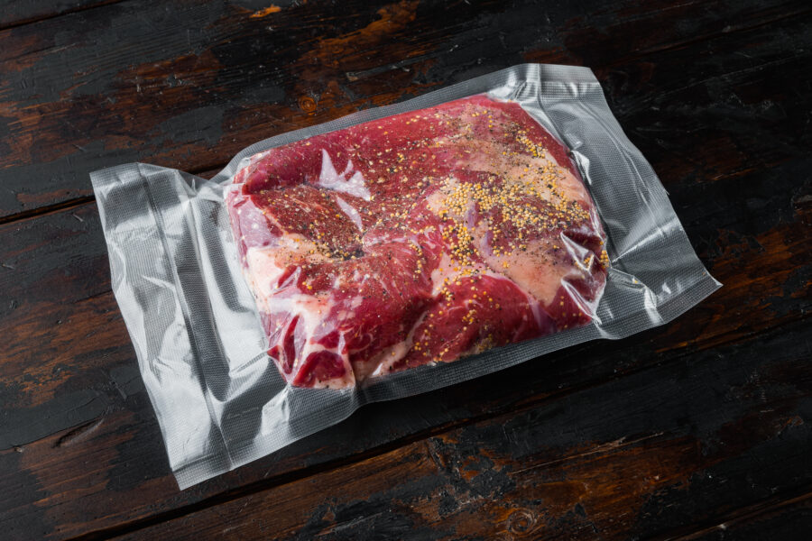 Raw veal calf brisket beef set,with ingredients for smoking  making  barbecue, pastrami, cure, vacuum sealed ready for sous vide cooking, on old dark  wooden table background,  with copy space for text