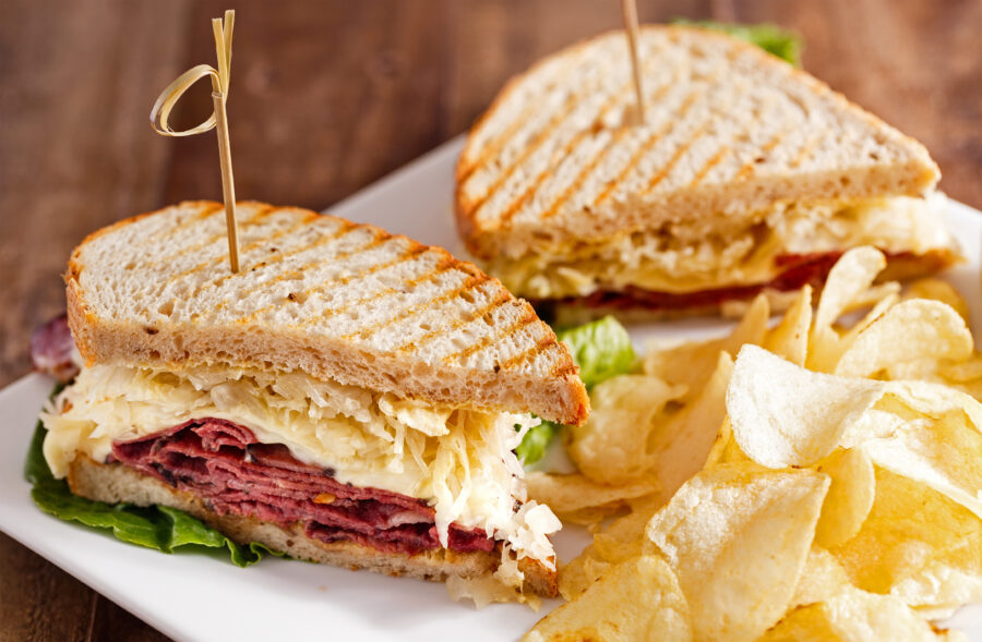 Reuben Sandwich Cut in Half and Served with Potato Chips at a Local Cafe