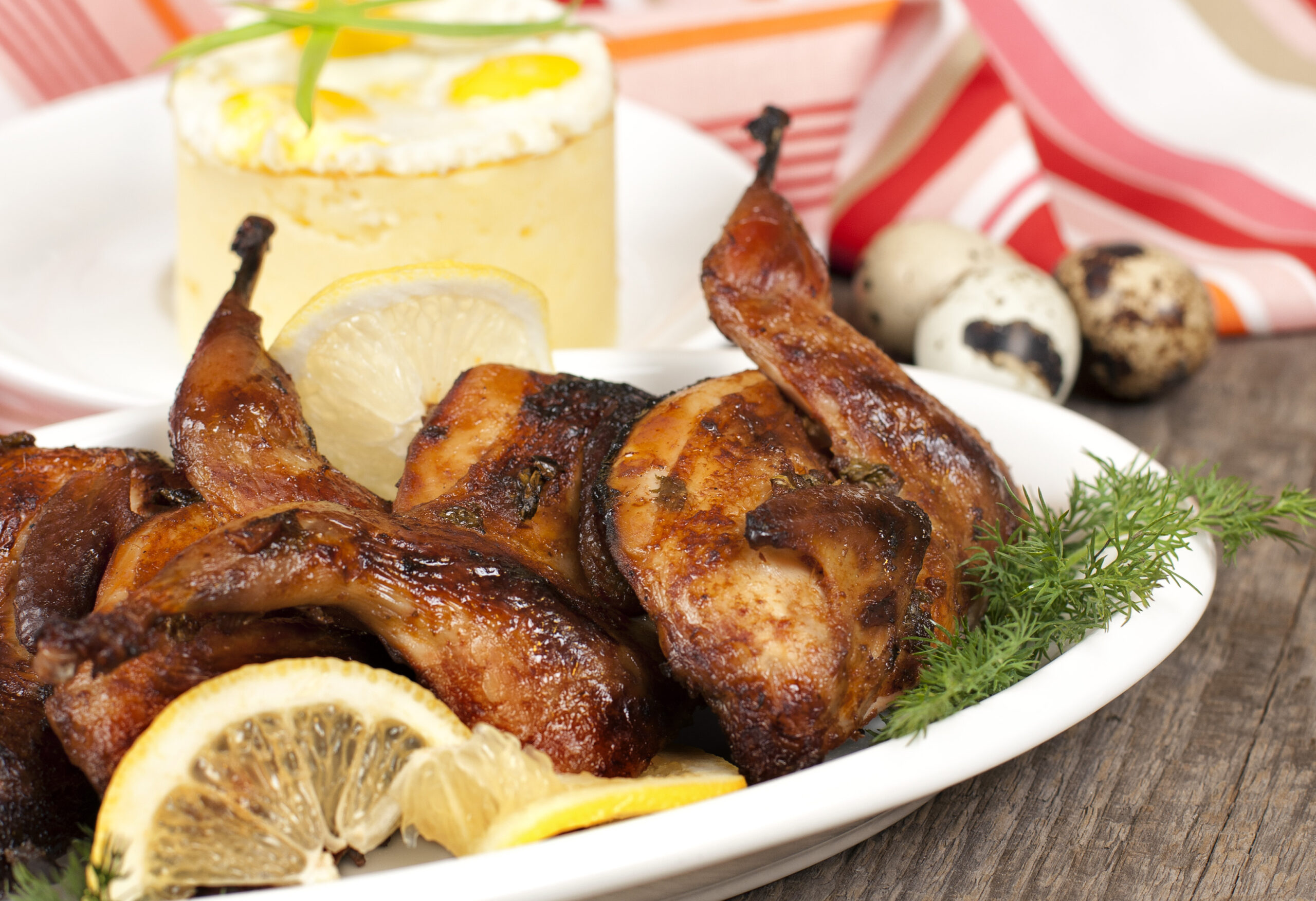 Roasted quail on white plate on the background of the mashed potato topping