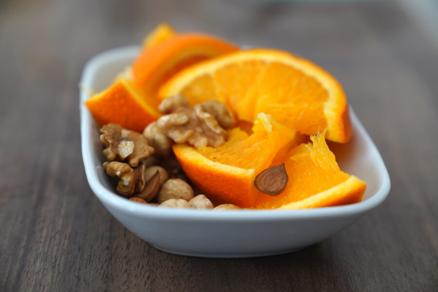 Sliced orange and nuts together in a bowl