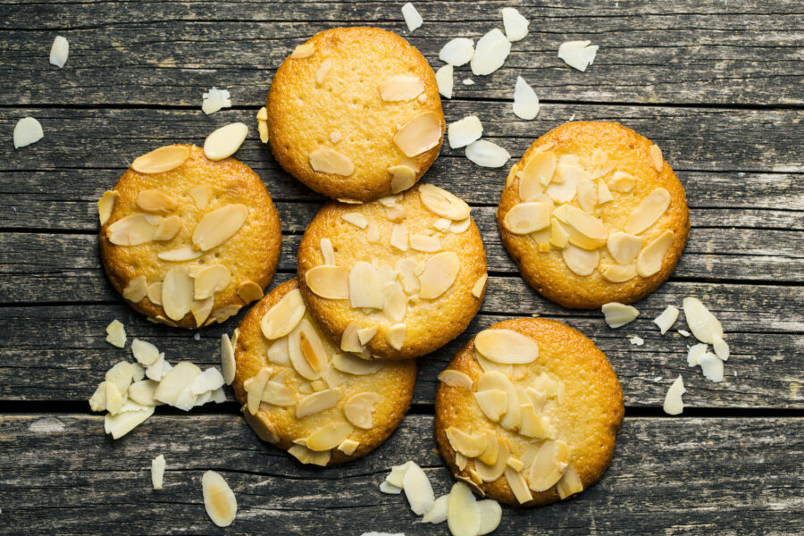 Sweet almond cookies on old wooden table. Black background. Top view.