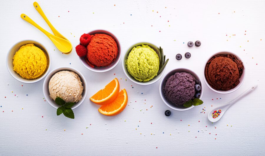 Various of ice cream flavor ball blueberry ,lime ,pistachio ,almond ,orange ,chocolate and vanilla set up on white wooden background . Summer and Sweet menu concept.