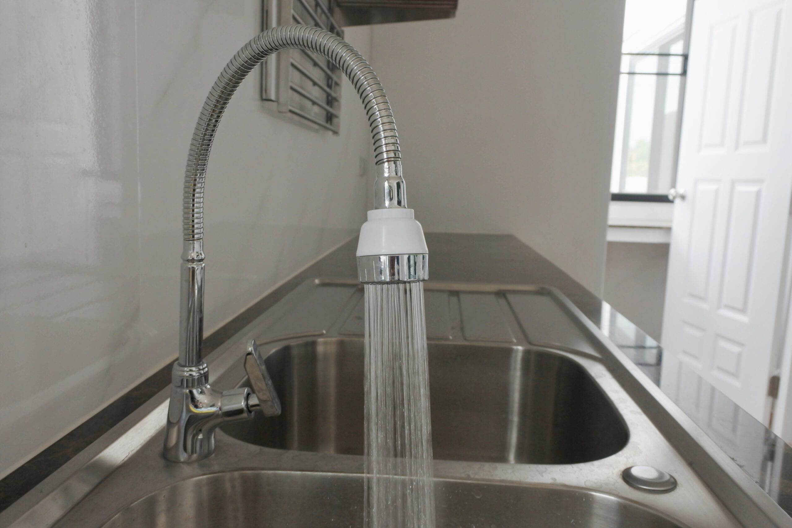 Water is flowing from the tap of sink in kitchen