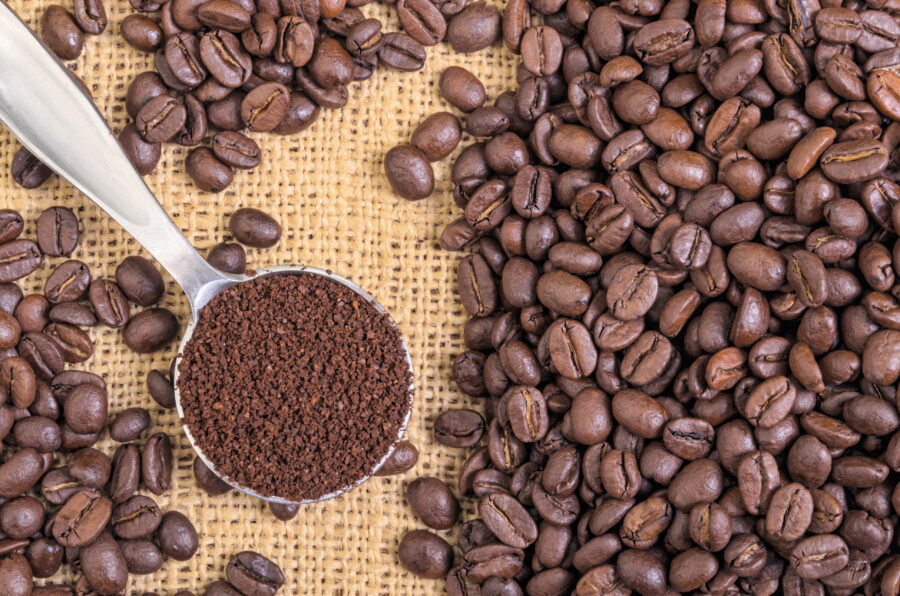 Whole Coffee Beans on Burlap with Ground Coffee in Spoon