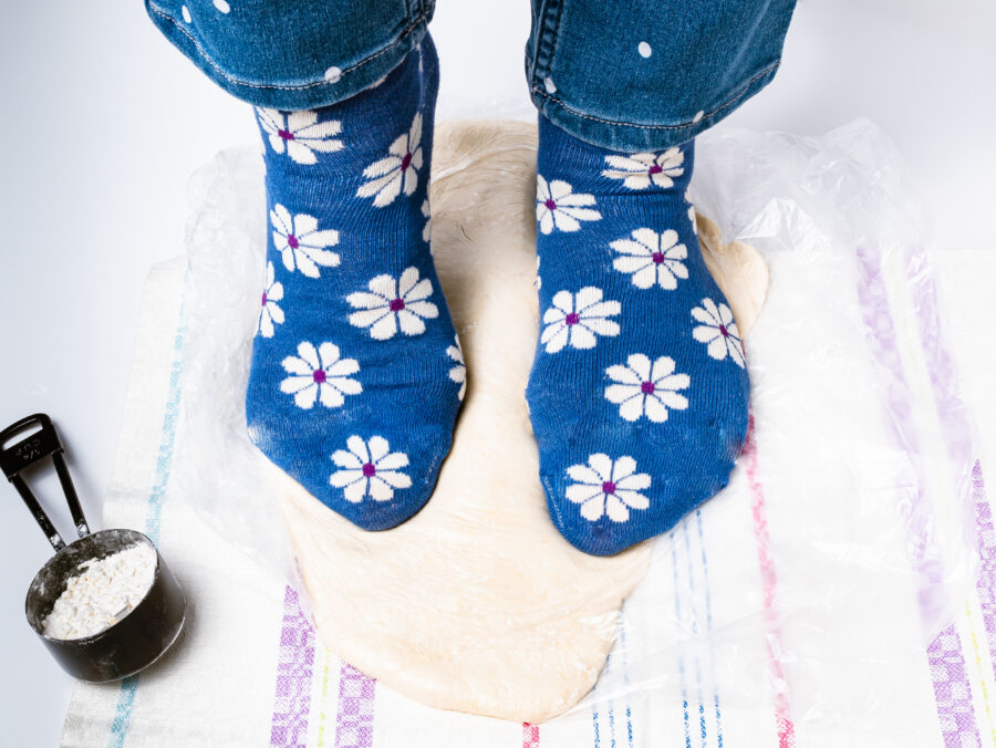 Woman's feet kneading Japanese udon noodle dough.